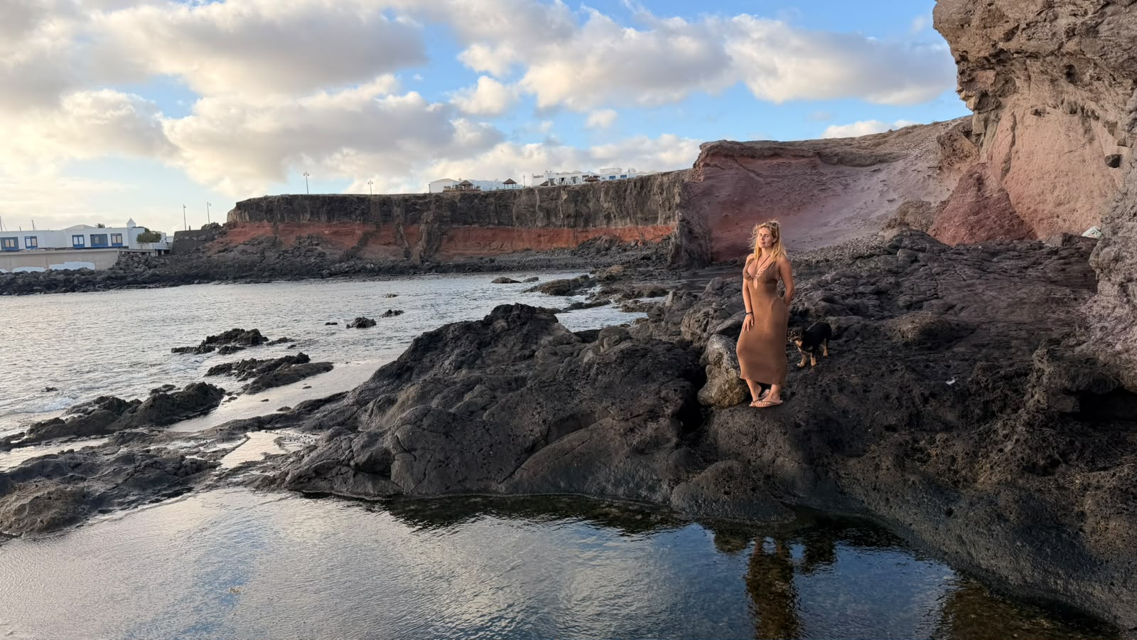 Sobre las rocas junto a las charcas de marea y los acantilados rojizos