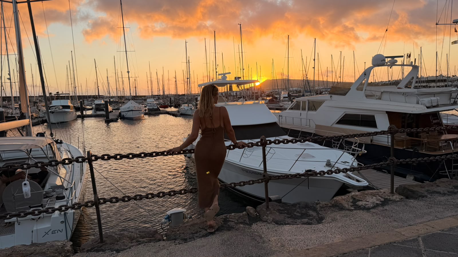 Atardecer dorado en el puerto deportivo entre veleros