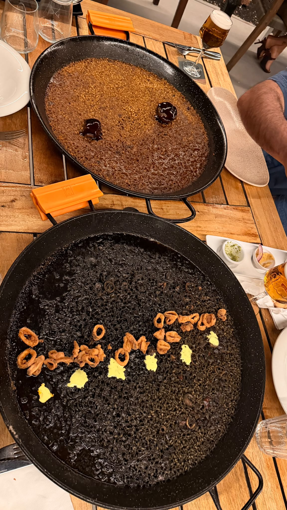 Arroz meloso y arroz negro con calamares y alioli en dos paelleras