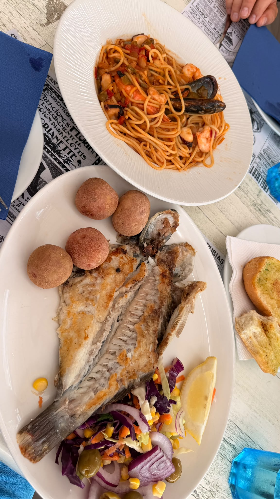 Pescado fresco a la plancha con papas arrugadas y ensalada, y espaguetis con marisco